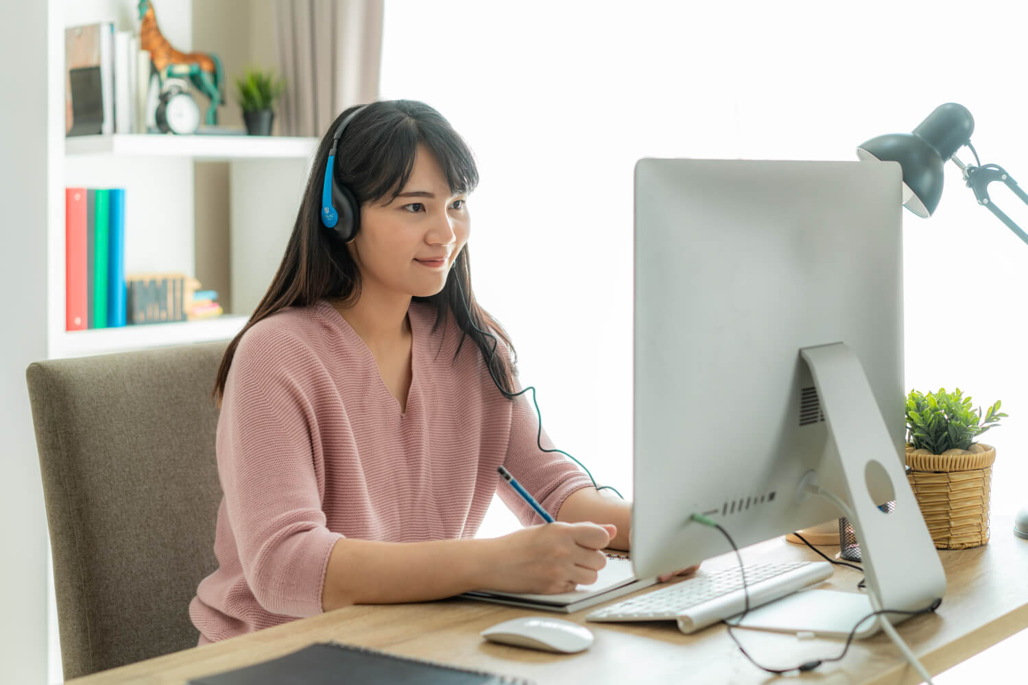 自宅でTOEICリスニングテストの対策をする女性のイメージ